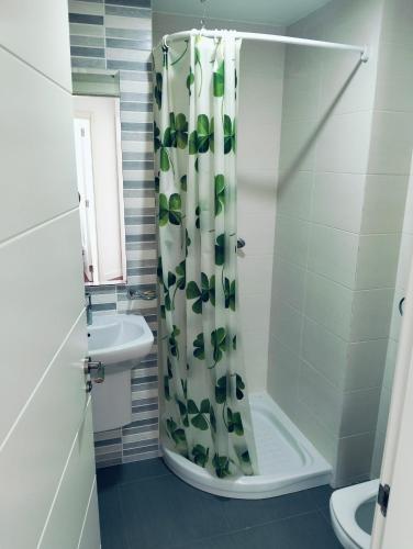 a bathroom with a shower curtain and a sink at apartamento victor in Cee