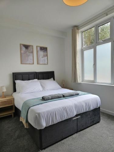 a bedroom with a large bed and two windows at Luxury Flat 10 mins from Station with BIKE ! in Cambridge