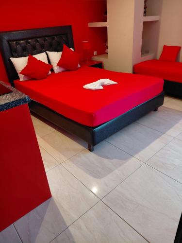 a red bed with red pillows in a room at Apartments Vesna Luxury & Michel ap 8 in Paralia Katerinis