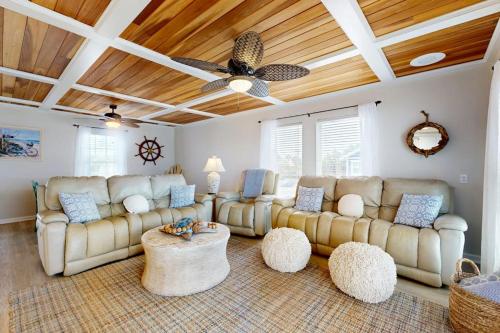 a living room with couches and a ceiling fan at KC's Seaside Sanctuary in Edisto Island