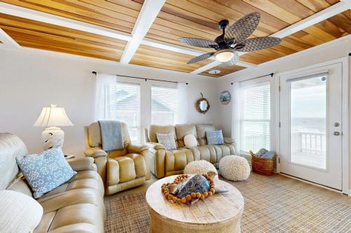 a living room with a couch and a ceiling fan at KC's Seaside Sanctuary in Edisto Island