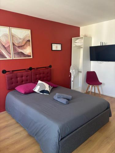 a bedroom with a large bed with red walls at Terra Cotta 1er Étage in Abbeville