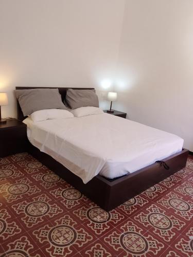 a bed in a bedroom with two tables and two lamps at Borgo antico Pisa in Montecastello