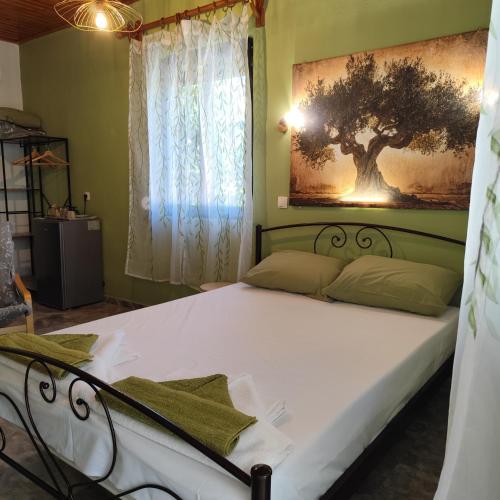a bedroom with a bed with a tree picture on the wall at Asmanis Rooms in Tarti