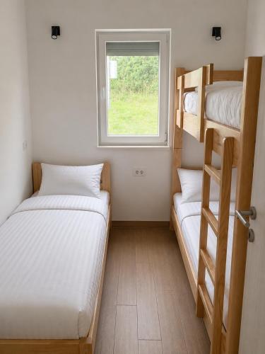 two bunk beds in a small room with a window at Davidovic House in Amzići