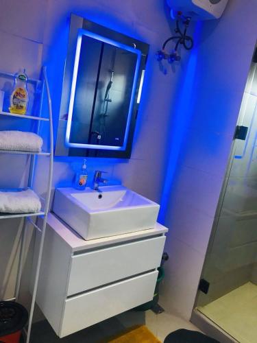 a bathroom with a white sink and a mirror at NewAge Smart 2 in Ikeja