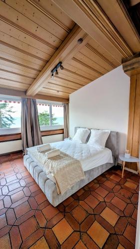 a large bed in a room with a wooden ceiling at Chillon lake view by MK in Montreux