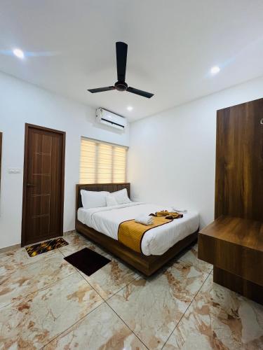 ein Schlafzimmer mit Bett und Deckenventilator in der Unterkunft Ocean Mist in Kozhikode