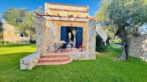 a stone house with a table and chairs in a yard at oleabungalows in Akrotiri