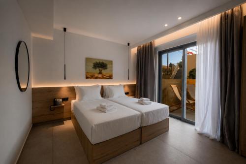 a bedroom with a bed and a large window at Tessera Boutique Hotel & Villas Collection in Gouvia