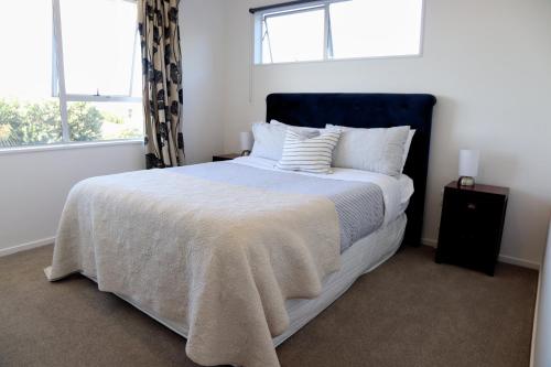a bedroom with a large bed with a blue headboard at Ocean Vista Hideaway in Kaikoura
