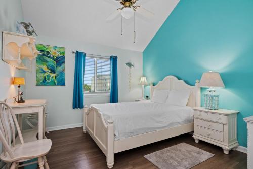 a bedroom with a white bed and a chair at Pebble Beach I-211 in Emerald Isle