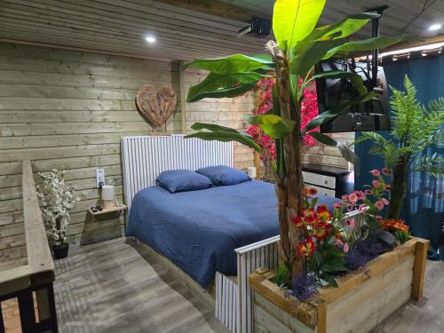 a bedroom with a bed and some plants and flowers at Gite de yaya in Cousance