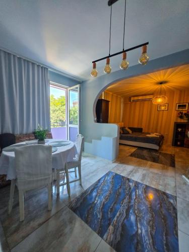 a dining room with a table and chairs and a couch at Guest House Medusa - Old town in Pomorie