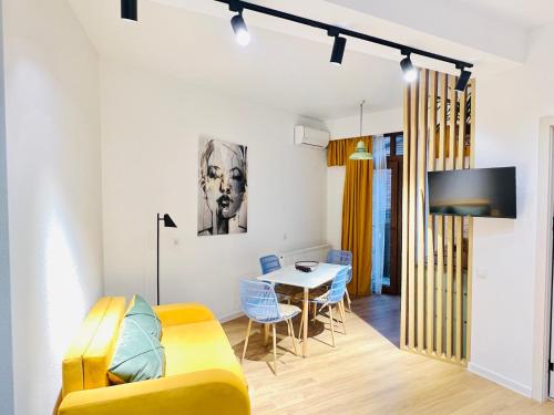 a living room with a yellow couch and a table at M Boutique Aparthotel in Tbilisi City