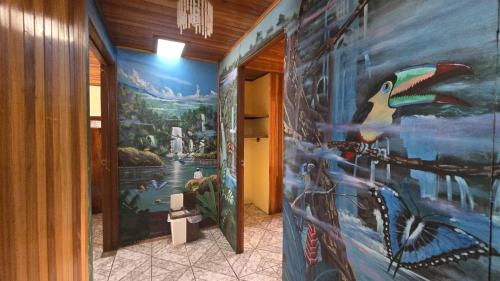 a hallway with a large painting on the wall at Monteverde Monkey Hostel in Monteverde Costa Rica