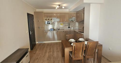 a kitchen with a table and chairs in a room at Sun Sea App in Shkorpilovtsi