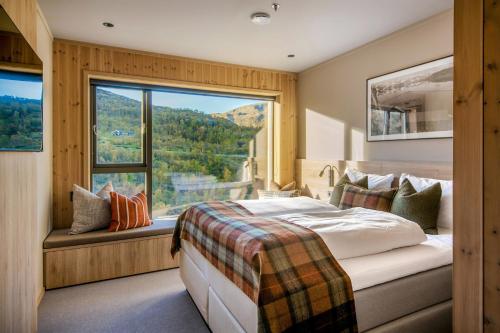 a bedroom with a bed and a large window at Filefjellstuene Hotel in Tyinkrysset