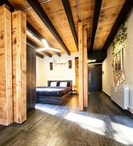 a bedroom with a bed and wooden ceilings at Farayayellowstone 1 bedroom with panoramic mountain view fit 4 in Bayn an Nuhūr