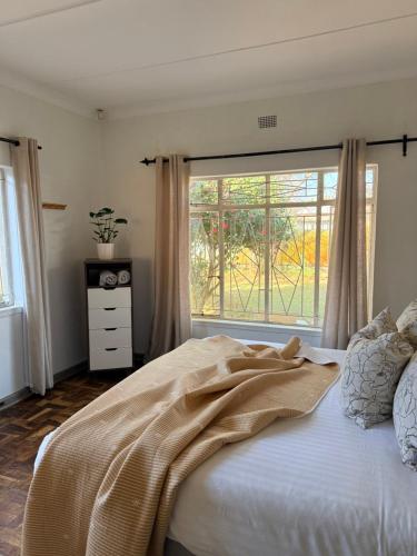 a bedroom with a bed with a large window at Lielies Guesthouse in Parys