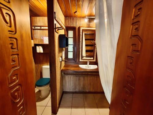 a bathroom with a sink and a toilet at Vahaui Paradis in Avatoru