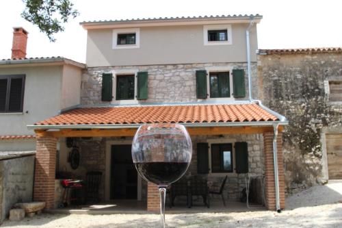 una copa de vino frente a una casa en Holiday Home Vinkovic, en Poreč
