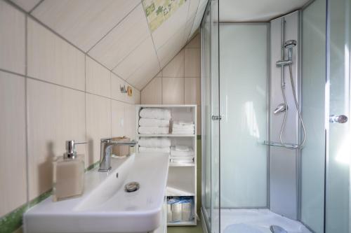 a white bathroom with a sink and a shower at Michell Apartman Martin in Martin