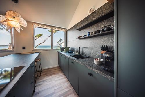 a kitchen with gray cabinets and a counter top at appartement Picasso - une évasion face à l'océan in Santec