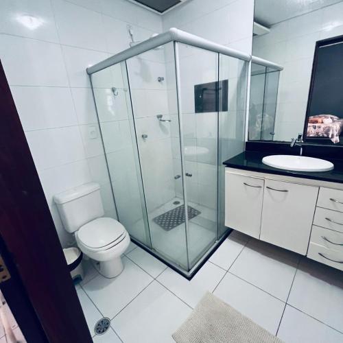 a bathroom with a shower and a toilet and a sink at Pousada Dipajuçara in Maceió