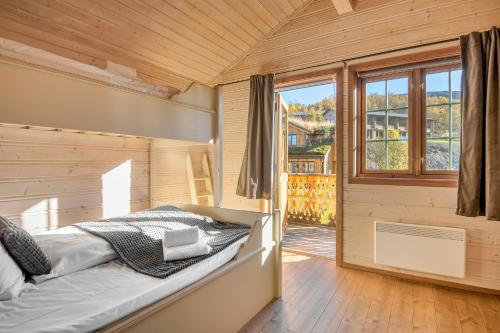 a bedroom with a bed and a large window at Filefjellstuene hytter og leiligheter in Tyinkrysset