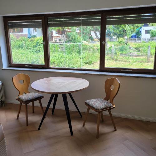 a table and two chairs in a room with a window at Ferienwohnung mit Bergblick in Oberammergau