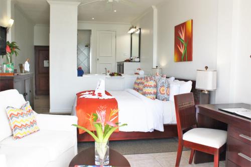 a bedroom with a bed and a desk and a table at Calabash Cove Resort and Spa - Adults Only in Gros Islet