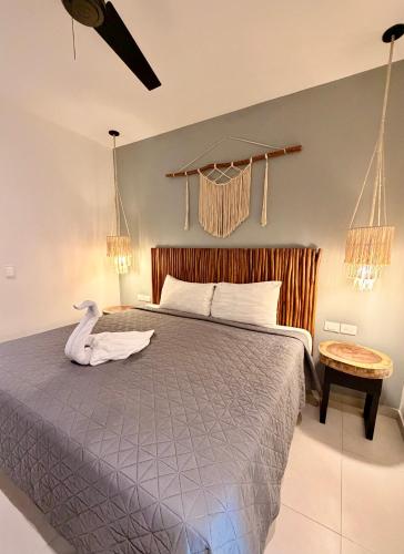 a bedroom with a bed with a swan on it at Ah Xok suites 5a Avenida in Playa del Carmen