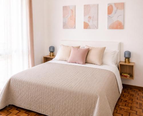a bedroom with a large white bed with pink pillows at Casa Lupoli in Caserta