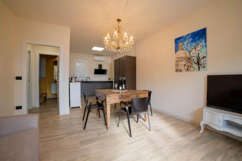 a dining room with a table and chairs and a television at Robur Gardae Panoramic Suite in Torri del Benaco