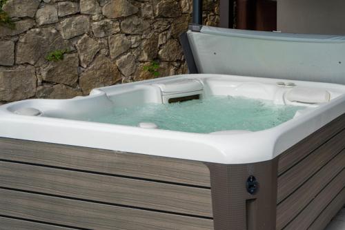 a white bath tub with blue water in it at Robur Gardae Panoramic Suite in Torri del Benaco