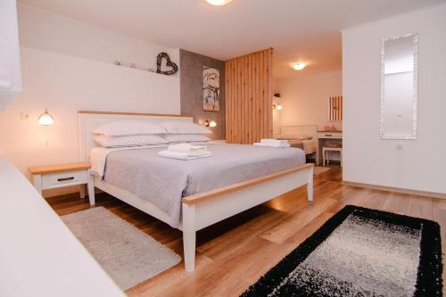 a bedroom with a bed and a living room at Soba i Apartman Đula in Ogulin