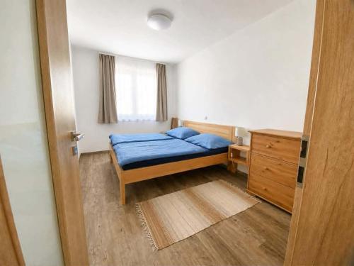 a small bedroom with a blue bed and a window at Rodinný dům Řásná u Telče in Řásná