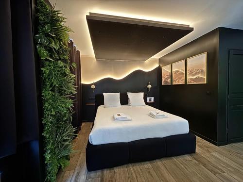 a bedroom with a large bed with white sheets at La Suite Aimée - Espace relaxant avec balnéo in Angoulême