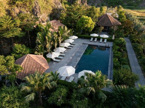 an aerial view of a resort swimming pool with white lounge chairs at An Hideaway Resort in Ninh Binh