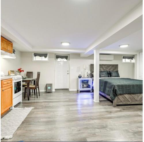 a bedroom with a bed and a kitchen with a table at Elmont Escape Studio in Elmont