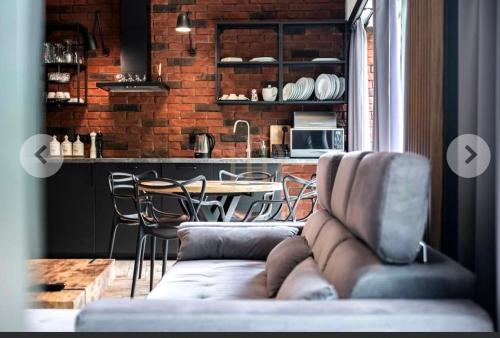 a living room with a couch and a table with chairs at Apartamenty Terminal Charzykowy in Charzykowy