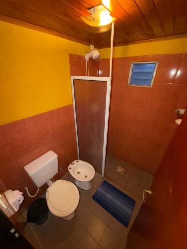 a small bathroom with a toilet and a shower at Cabaña en la Naturaleza, próximo a las Cataratas - Oré Lodge in Puerto Iguazú