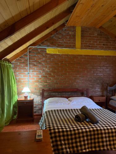 a bedroom with a bed and a brick wall at Cabaña en la Naturaleza, próximo a las Cataratas - Oré Lodge in Puerto Iguazú