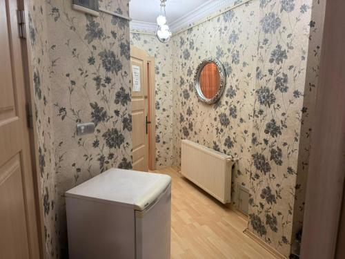 a bathroom with floral wallpaper and a toilet in a room at Ramonun Yeri in Istanbul