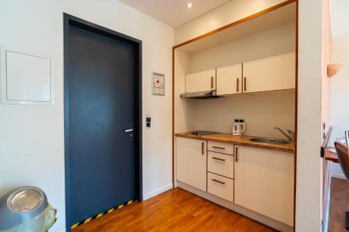a kitchen with a black door leading into a room at Juno Suites Bremen City in Bremen