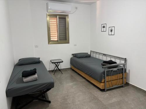 a bedroom with two beds and a window at Rest&breath in Nir Yafe