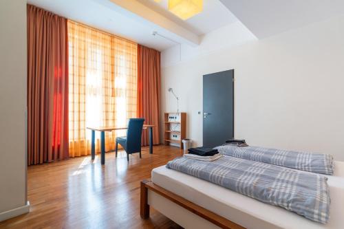 a bedroom with a bed and a desk and a table at Juno Suites Bremen City in Bremen