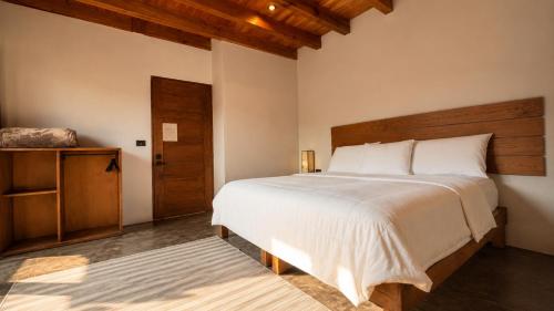 a bedroom with a large bed with a wooden headboard at Villa Maria Hotel in Valle de Bravo