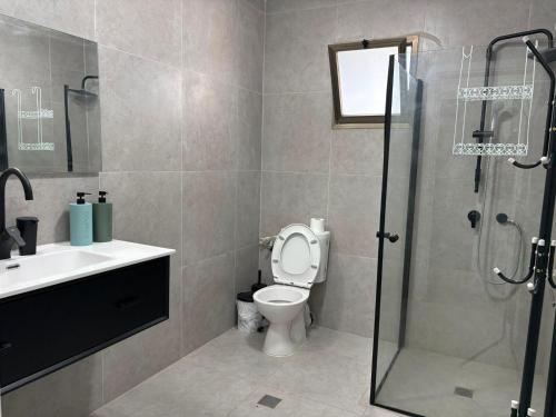 a bathroom with a toilet and a sink and a shower at Rest&breath in Nir Yafe
